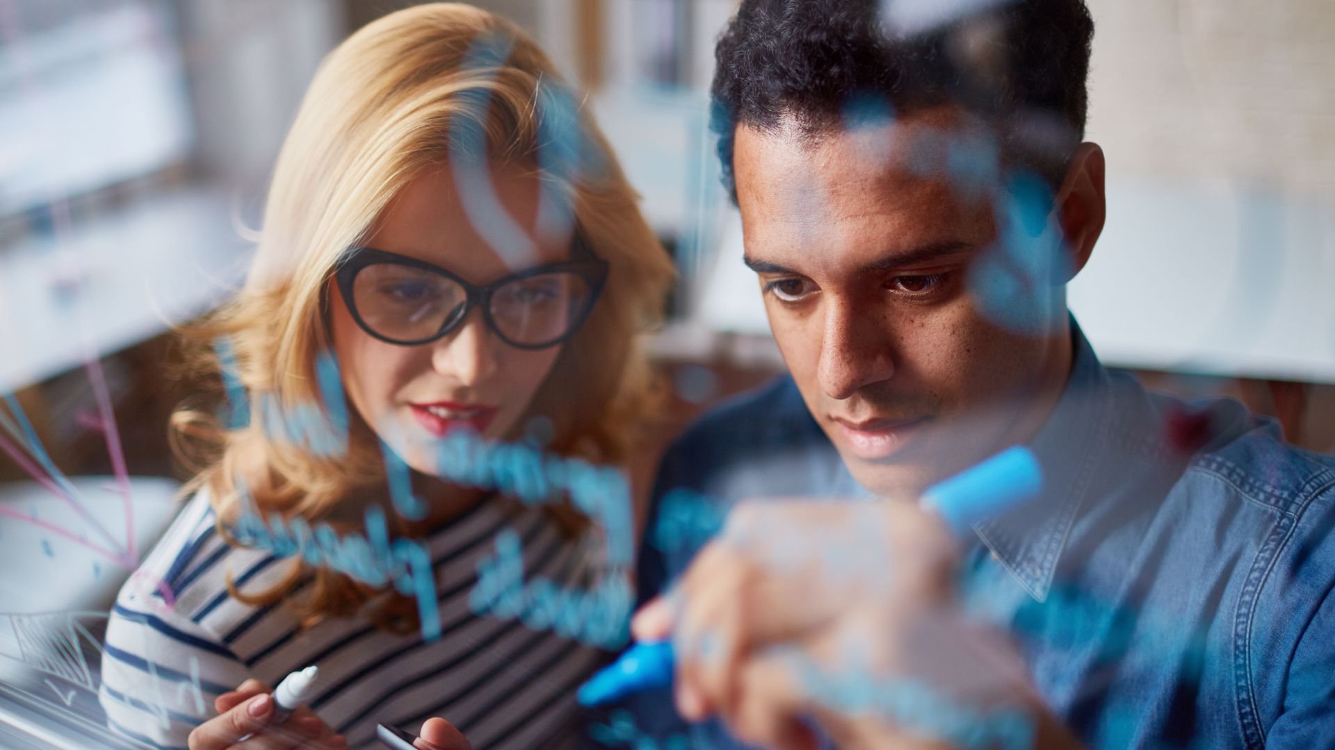 Two colleagues collaborating on a project, looking intently at shared work
