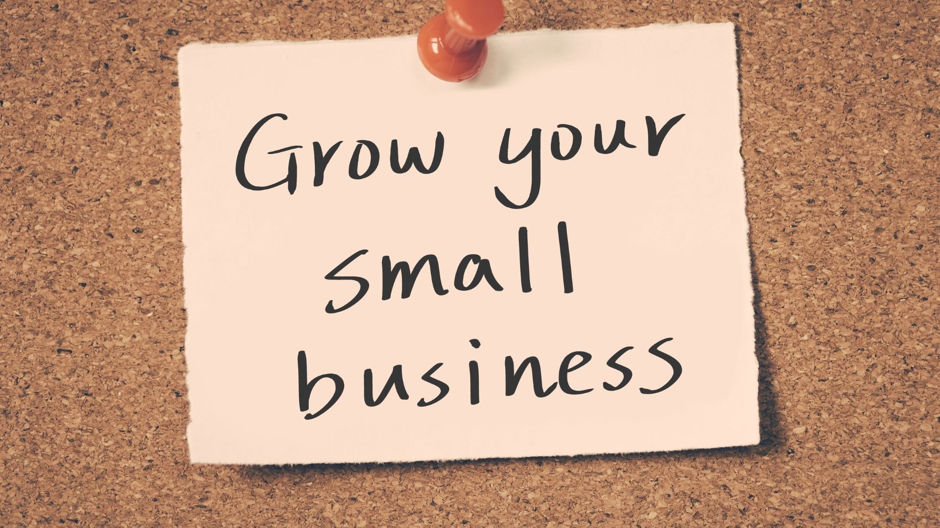 Motivational note pinned to cork board: Grow your small business